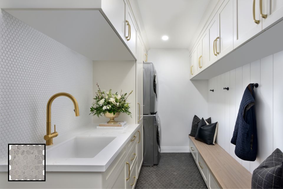 white laundry mudroom with penny tile backsplash behind sink and gold metal hardware